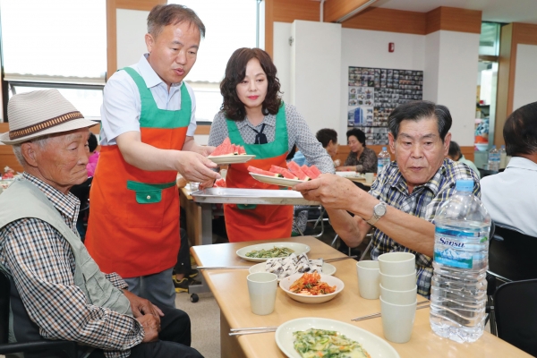 이재수 시장이 사회복지봉사단 단원과 함께 어르신에게 수박을 나르고 있다. 사진=춘천시