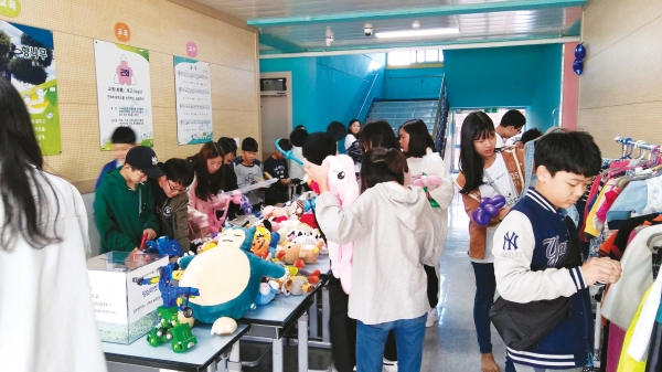 근화초등학교 가을축제 프리마켓에서 학생들이 물건을 고르고 있다.