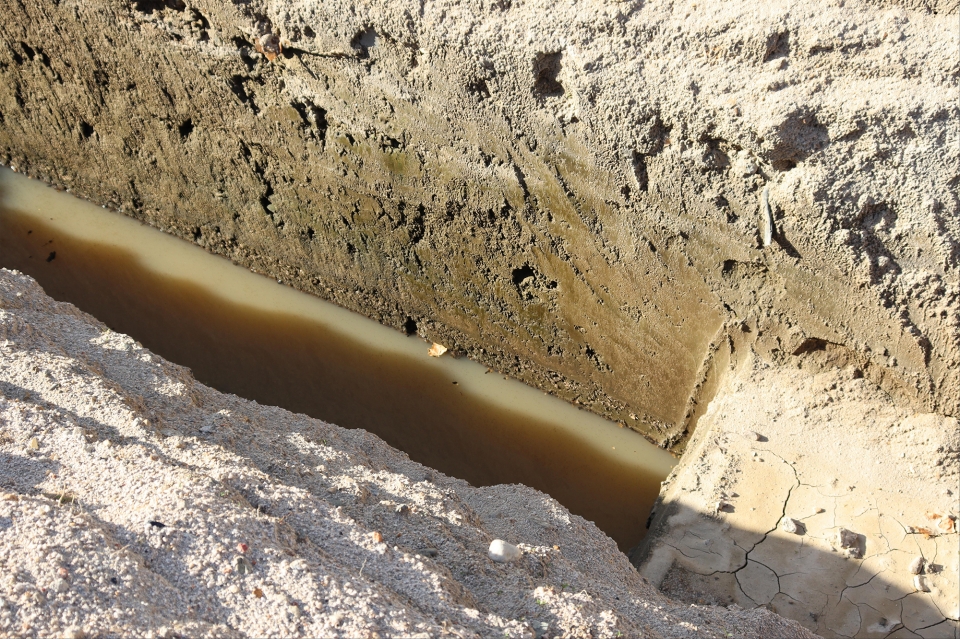 캠프페이지 내 토양오염을 잘 보여주는 기름띠. 가운데 암갈색이 기름에 오염된 층이다.