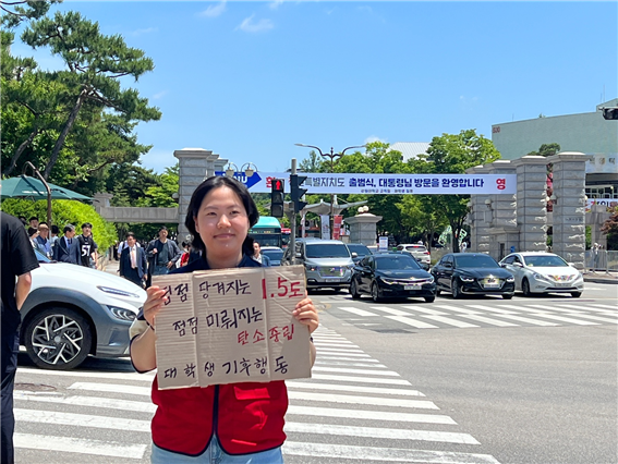 강원대 정문 앞에서 피켓을 들고 홍보활동 중인 김유진 활동가.
